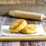 Freshly baked golden biscuits made with pancake mix, stacked on a plate with butter melting on top.